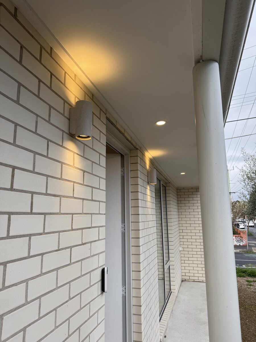 Wall lights and recessed downlights at a covered entrance