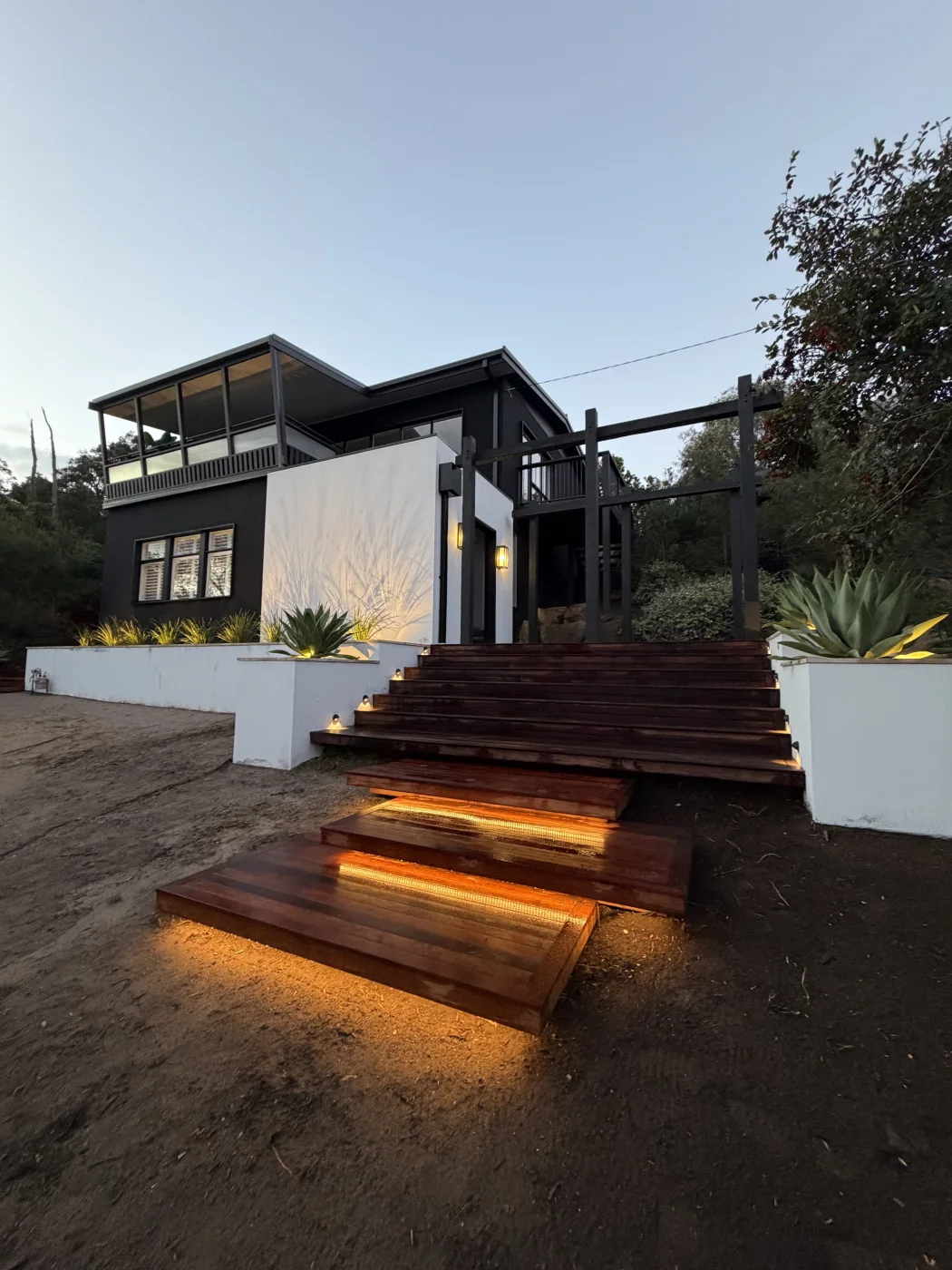 Exterior house and timber stair lighting at dusk